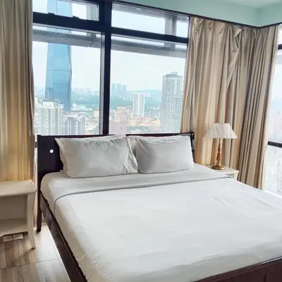a bed in a room with a large window at Times Square Apartment By Skyline in Kuala Lumpur