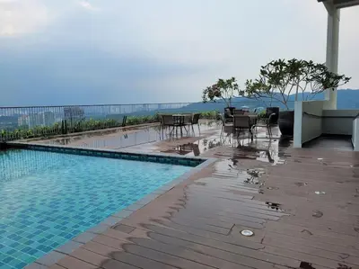 a swimming pool with tables and chairs on a building at OOAK Residence at Mont Kiara in Kuala Lumpur