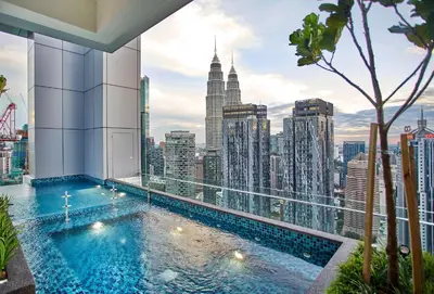 a swimming pool on top of a building with a city skyline at Royce Residence KLCC by Cobnb in Kuala Lumpur