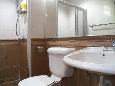 a bathroom with a sink and a toilet and a mirror at Maytower Apartment in Kuala Lumpur