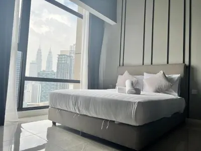 a bed with a teddy bear sitting on it in front of a window at Axon Bukit Bintang By Moonlight in Kuala Lumpur