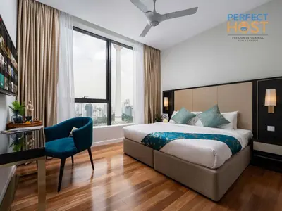 a hotel room with a bed and a blue chair at Pavilion Ceylon Hill Suites, KLCC in Kuala Lumpur