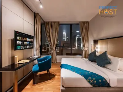 a hotel room with a bed and a desk and a room with a view at Pavilion Ceylon Hill Suites, KLCC in Kuala Lumpur