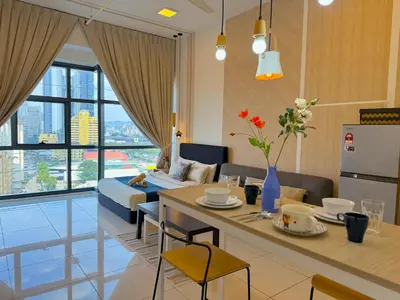 a kitchen and living room with a table and a couch at 3 Towers Jalan Ampang By Serenity Vacation Homes in Kuala Lumpur