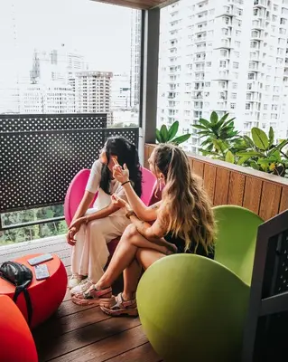 three women sitting in chairs in a room with a window at Ceylonz Suite Kuala Lumpur Bukit Bintang in Kuala Lumpur