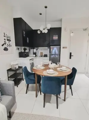 a dining room with a table and chairs and a kitchen at Designer Studio Arte Mont Kiara in Kuala Lumpur
