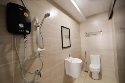a bathroom with a shower with a toilet and a sink at 3Towers @ KL City Centre in Kuala Lumpur