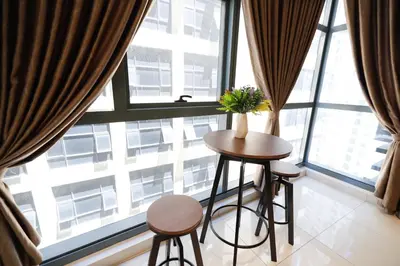 a table and two stools in front of a large window at 3Towers @ KL City Centre in Kuala Lumpur
