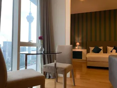 a room with a table and a bed and a bedroom at The Platinum KLCC By Victoria Home in Kuala Lumpur
