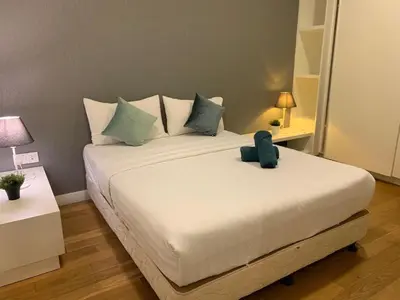 a bedroom with a large white bed with blue pillows at The Platinum KLCC By Victoria Home in Kuala Lumpur