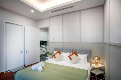 a bedroom with a large bed with white walls at Royce Residence KLCC, Kuala Lumpur City Center, COBNB in Kuala Lumpur