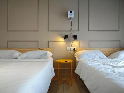 two beds with white sheets and a table between them at TRION Studio 4 PAX Teneighth in Kuala Lumpur