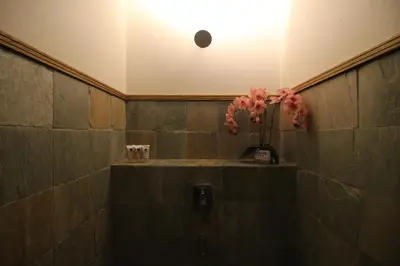 a bathroom with a vase of flowers on a shelf at de King Hotel KLCC in Kuala Lumpur