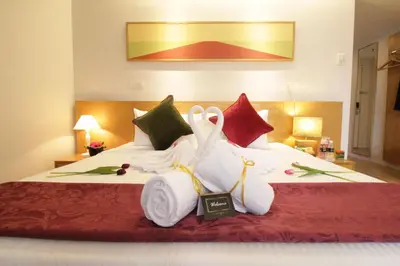 a hotel room with a bed with swans made out of towels at de King Hotel KLCC in Kuala Lumpur