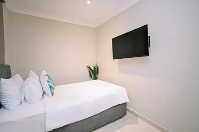 a bedroom with a white bed with a flat screen tv at Kingston Hotel 6 - Changkat, Bukit Bintang in Kuala Lumpur