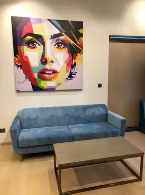 a blue couch in a living room with a painting at Star Residence KlCC By M&T in Kuala Lumpur