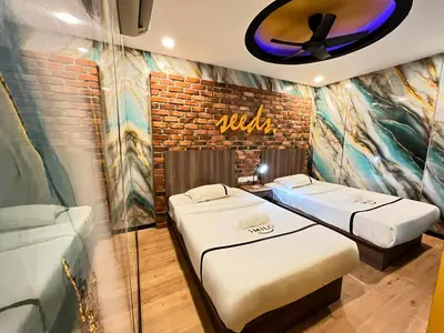 two twin beds in a room with a wall at Seeds Hotel Cheras Maluri in Kuala Lumpur