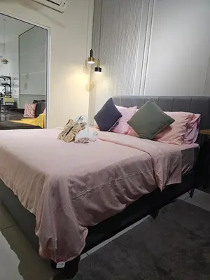 a bedroom with a large bed with pink and green pillows at Anggun Arte Mont Kiara in Kuala Lumpur