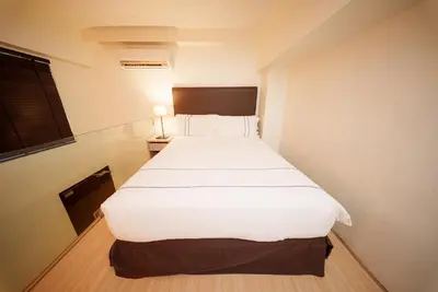 a large white bed in a small room at The Mesui Hotel Bukit Bintang in Kuala Lumpur