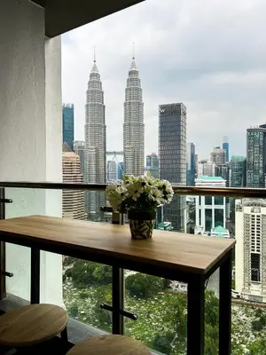 a vase of flowers sitting on a table in a window at Leaves @ Legasi KLCC View, Kg Baru KL in Kuala Lumpur