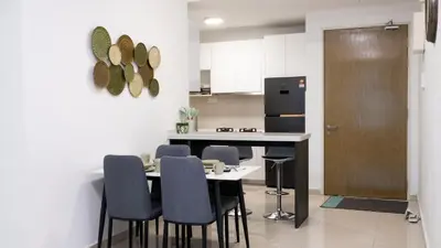 a kitchen with a table and chairs and a refrigerator at Leaves @ Legasi KLCC View, Kg Baru KL in Kuala Lumpur