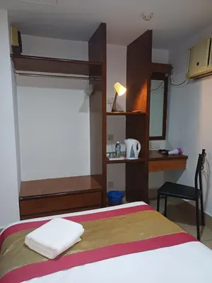a bedroom with a bed with a desk and a mirror at Hotel Seri Putra in Kuala Lumpur