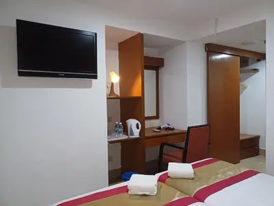 a hotel room with a bed and a television on a wall at Hotel Seri Putra in Kuala Lumpur