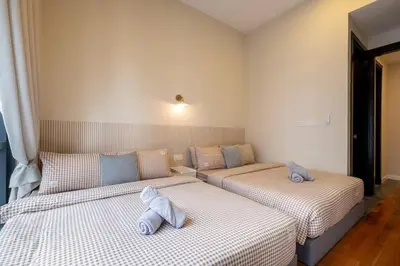 two beds in a room with white sheets at The Element Ampang in Kuala Lumpur