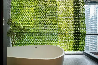 a green wall with a white table in front of a window at The Element Ampang in Kuala Lumpur