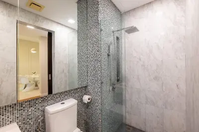 a bathroom with a toilet and a glass shower at The Element Ampang in Kuala Lumpur
