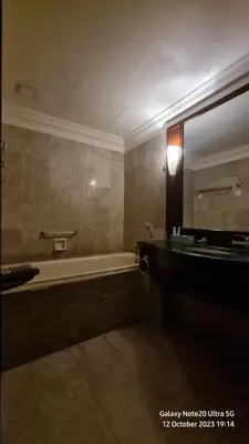 a bathroom with a tub and a sink and a mirror at Regal Servies Suites at Times Square KL in Kuala Lumpur