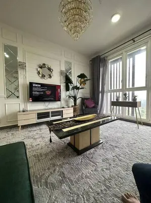 a large living room with a table and a television at Elisa Sentrio Pandan Suites in Kuala Lumpur