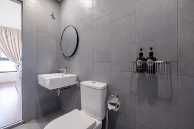 a bathroom with a toilet and a sink and a mirror at M Vertica KL Residence Tower E by Feel Home in Kuala Lumpur
