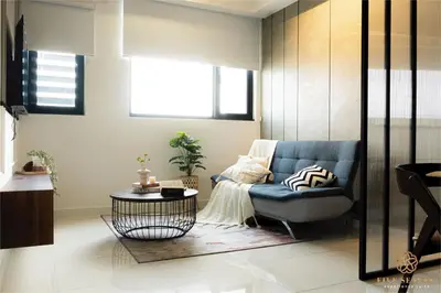 a living room with a blue chair and a table at Chambers Signature Suites, Kuala Lumpur in Kuala Lumpur