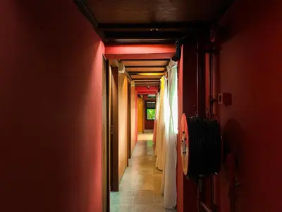a hallway with red walls and a hallway with doors at Hotel O I.villa Inn in Kuala Lumpur