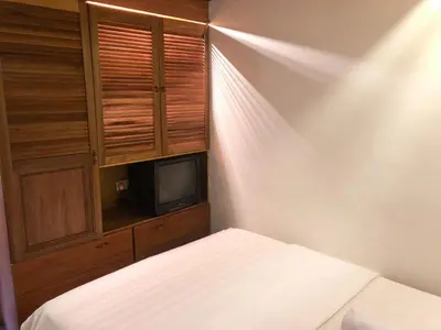a bedroom with a bed and a cabinet and a tv at Hotel O I.villa Inn in Kuala Lumpur