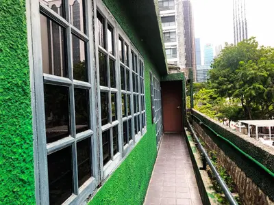 a green building with windows and a walkway at Hotel O I.villa Inn in Kuala Lumpur
