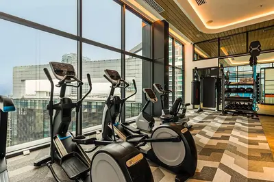 a gym with several cardio bikes in a room with windows at ViiA Residence, Mid Valley KL in Kuala Lumpur