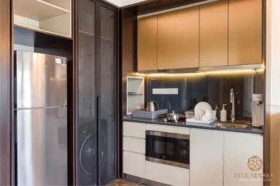a kitchen with brown cabinets and a stainless steel refrigerator at Scarletz Signature Suites, KLCC in Kuala Lumpur