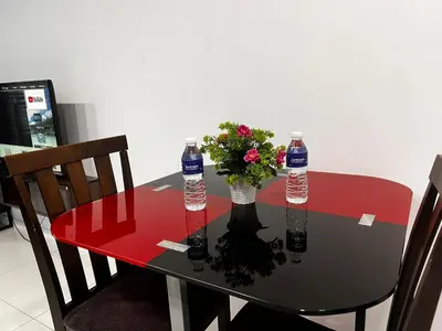a table with two bottles of water and flowers on it at Summer Suites KLCC By Homestay in Kuala Lumpur