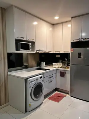 a kitchen with a washing machine and a microwave at Summer Suites KLCC By Homestay in Kuala Lumpur
