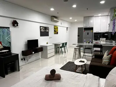 a living room with a couch and a kitchen at Summer Suites KLCC By Homestay in Kuala Lumpur