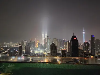 a view of a city skyline at night at Regalia Comfort Suites KLCC SkyPool in Kuala Lumpur