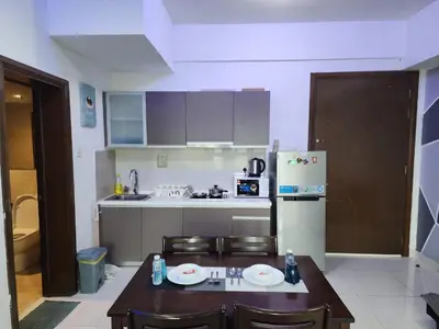 a small kitchen with a table and a refrigerator at Regalia Comfort Suites KLCC SkyPool in Kuala Lumpur