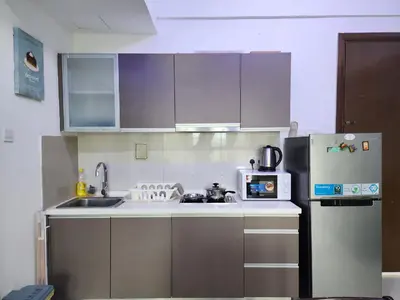 a kitchen with a sink and a refrigerator at Regalia Comfort Suites KLCC SkyPool in Kuala Lumpur