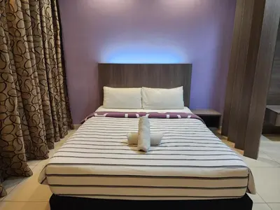 a bed with a stuffed animal sitting on top of it at Regalia Comfort Suites KLCC SkyPool in Kuala Lumpur