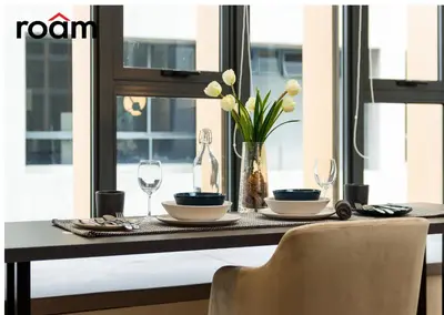 a dining room table with two glasses and a vase with flowers at Ceylonz Signature Suites, Bukit Bintang in Kuala Lumpur