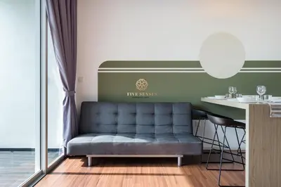 a living room with a blue couch and a table at UNA Signature Suites, Sunway KL in Kuala Lumpur