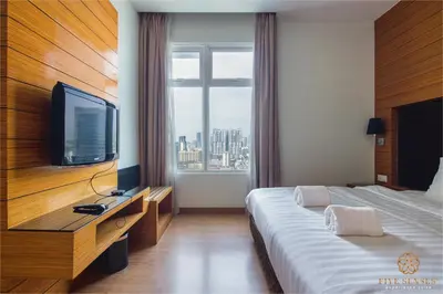 a hotel room with a large bed and a television at Dua Sentral Signature Suites in Kuala Lumpur