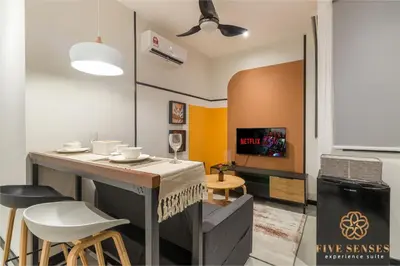 a living room with a table and some chairs at Neu Suites Signature Suites, KLCC in Kuala Lumpur
